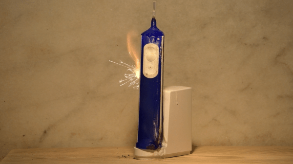 An electric toothbrush catches fire and sparks on its charging dock.